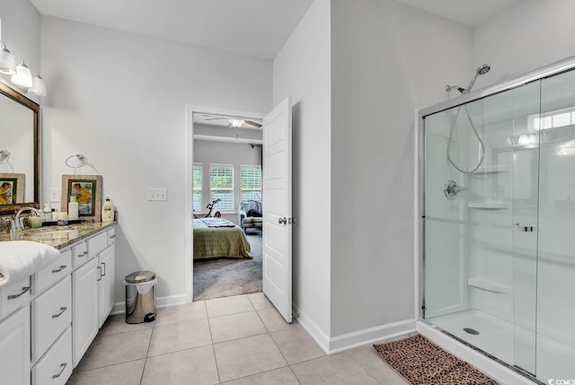 bathroom with tile patterned floors, ceiling fan, a shower with door, and vanity