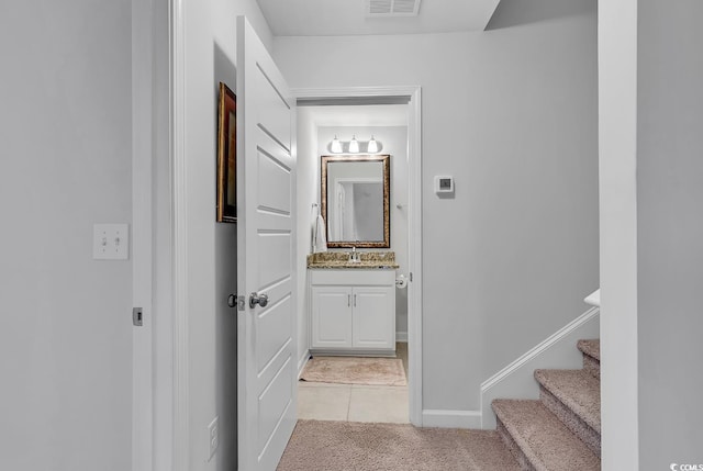 hallway with light tile patterned flooring and sink