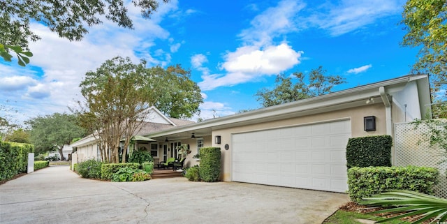 ranch-style home featuring covered porch, a garage, and ceiling fan