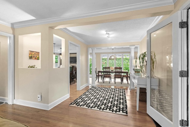 interior space with crown molding, hardwood / wood-style floors, and a textured ceiling