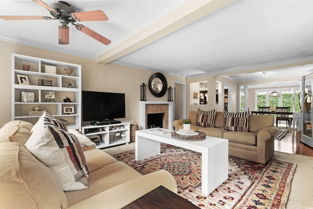 living room featuring hardwood / wood-style floors, ceiling fan, ornamental molding, and beamed ceiling