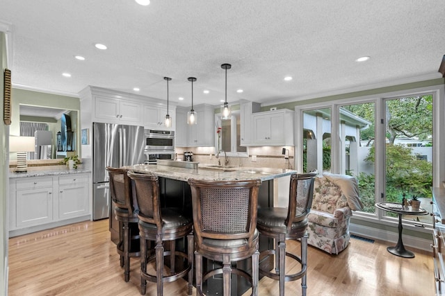 kitchen featuring white cabinets, decorative light fixtures, and ornamental molding