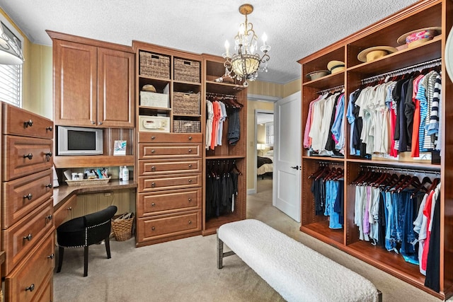 walk in closet with light carpet and an inviting chandelier