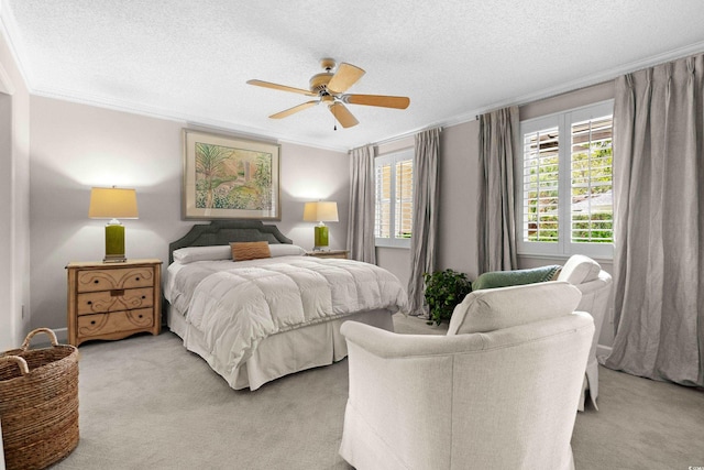 bedroom featuring a textured ceiling, ceiling fan, crown molding, and light carpet