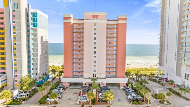 view of building exterior featuring a beach view and a water view