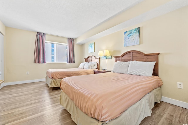 bedroom featuring light hardwood / wood-style floors and a textured ceiling