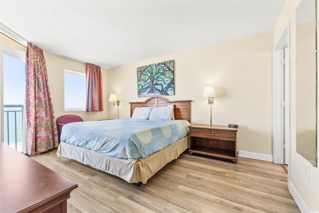 bedroom with light hardwood / wood-style floors and a textured ceiling