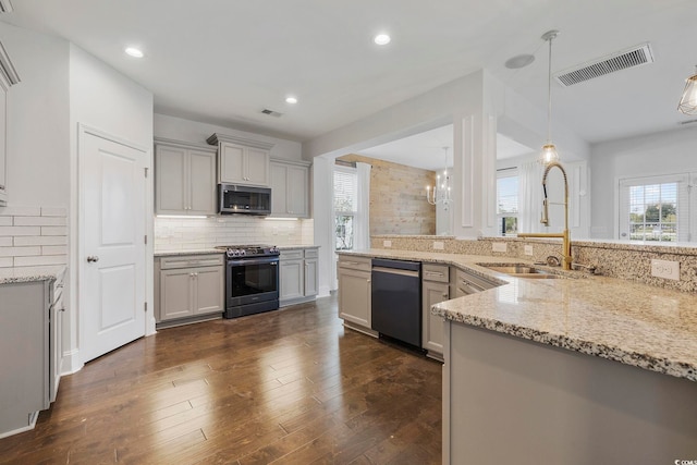 kitchen with gray cabinetry, stainless steel appliances, dark hardwood / wood-style floors, and decorative light fixtures