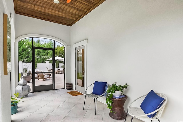 interior space featuring wooden ceiling, light tile patterned floors, and high vaulted ceiling