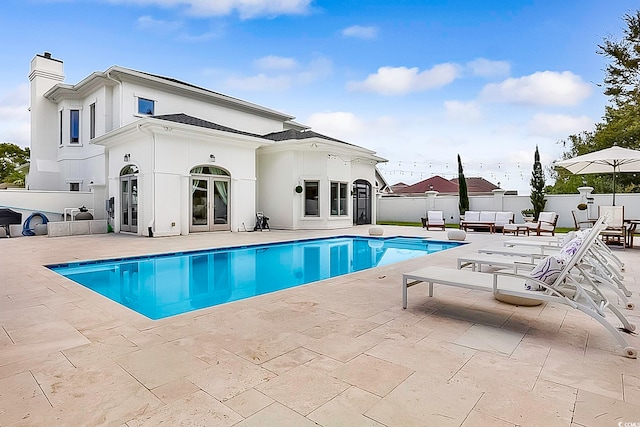 view of swimming pool featuring french doors and a patio area