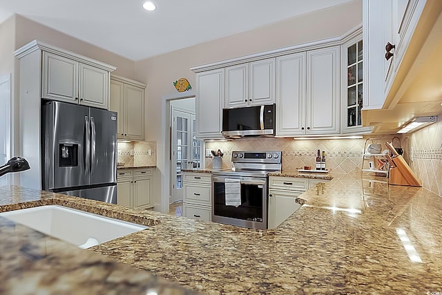 kitchen featuring tasteful backsplash, appliances with stainless steel finishes, sink, and light stone counters