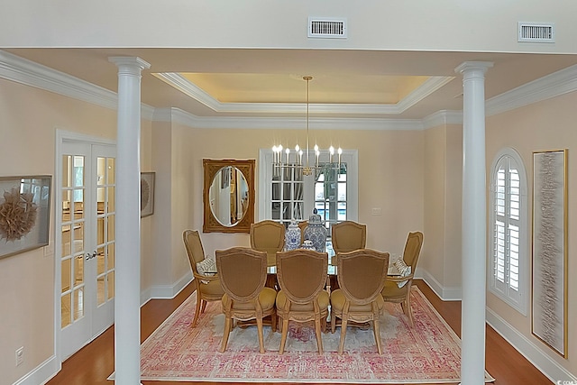 dining room with hardwood / wood-style floors, a chandelier, french doors, and decorative columns