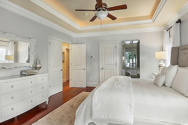 bedroom with ceiling fan, crown molding, dark hardwood / wood-style floors, and a raised ceiling