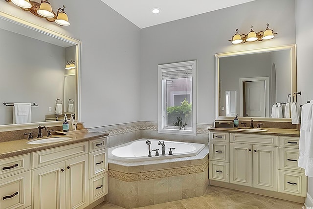 bathroom with vanity and tiled tub