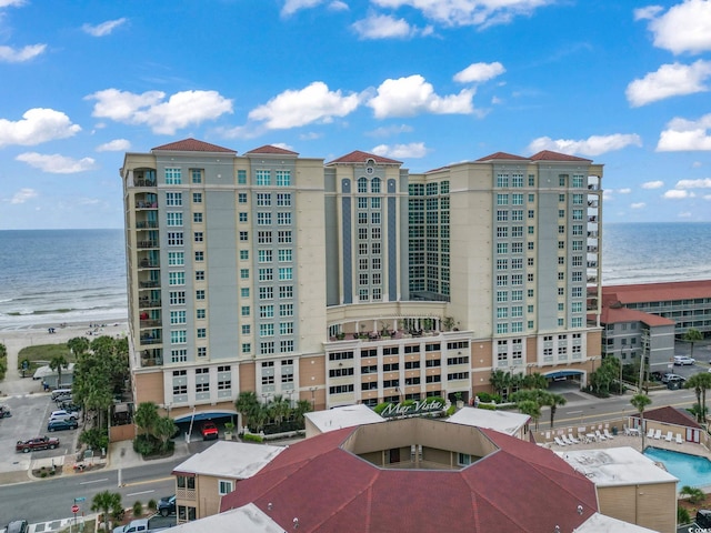 view of building exterior with a water view and a view of the beach