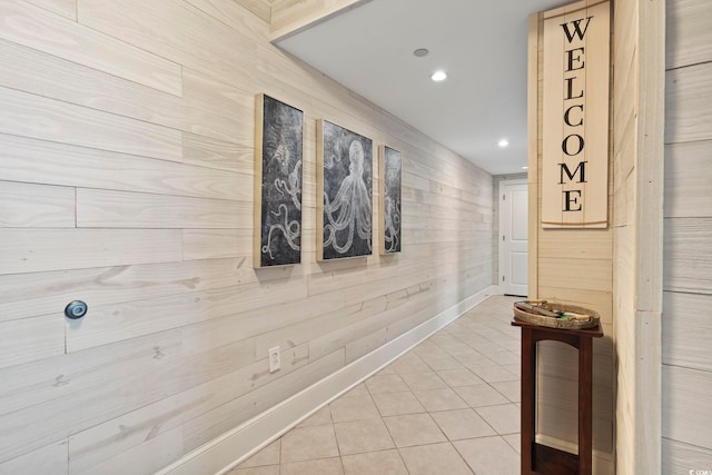 corridor featuring tile patterned flooring and wooden walls