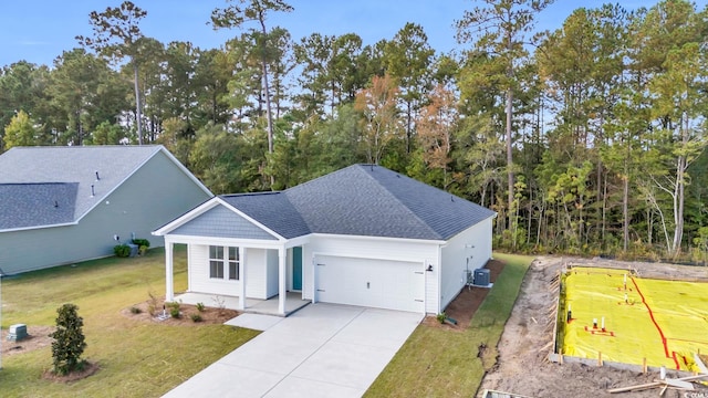 view of front facade with a garage, central AC, concrete driveway, a front yard, and roof with shingles