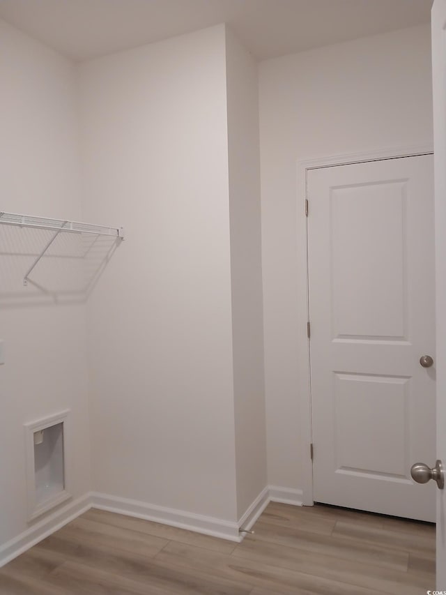 clothes washing area featuring light wood-type flooring