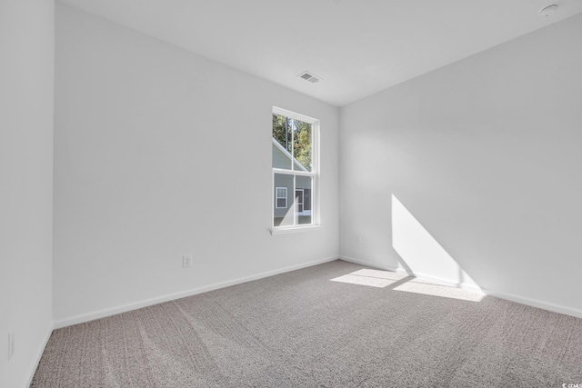 unfurnished room with carpet, baseboards, and visible vents