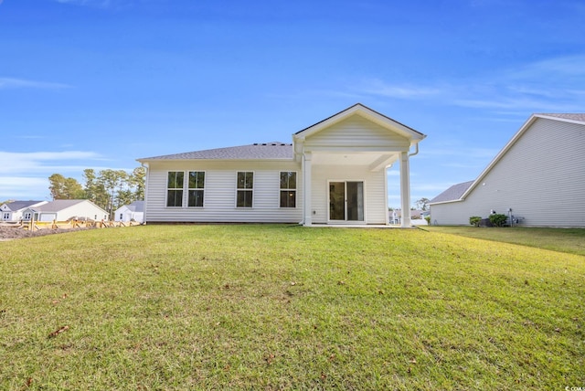 rear view of property with a yard