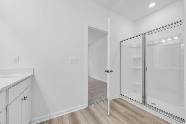 bathroom with vanity, recessed lighting, baseboards, a stall shower, and wood finished floors