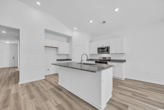 kitchen featuring stainless steel appliances, light wood-type flooring, sink, white cabinets, and a kitchen island with sink