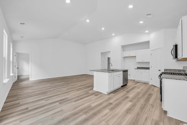 kitchen featuring appliances with stainless steel finishes, a center island with sink, vaulted ceiling, and light hardwood / wood-style flooring