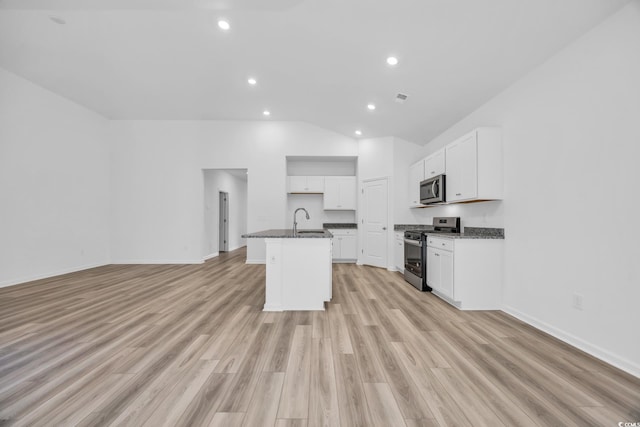 kitchen with stainless steel appliances, sink, an island with sink, and light hardwood / wood-style flooring