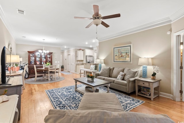 living room with crown molding, ceiling fan with notable chandelier, and light hardwood / wood-style floors