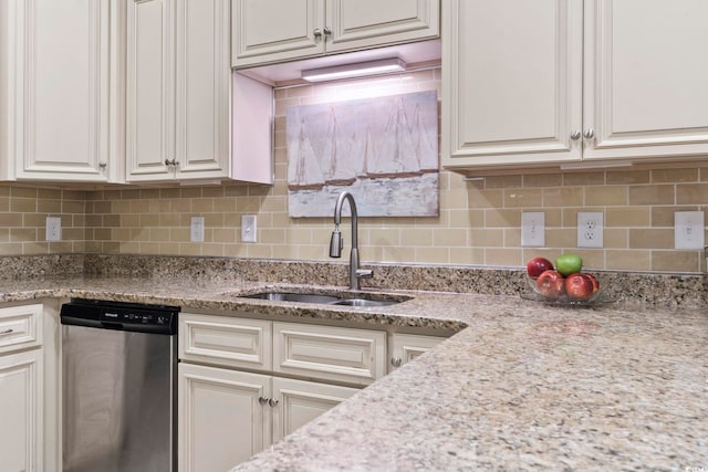 kitchen with sink, light stone counters, white cabinetry, stainless steel dishwasher, and backsplash