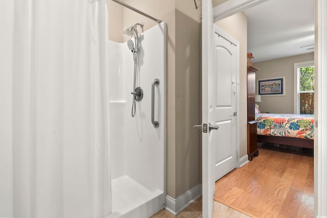 bathroom with walk in shower and hardwood / wood-style floors