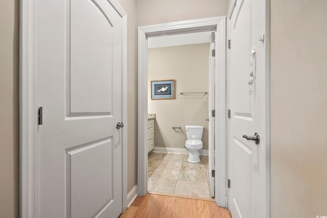 bathroom featuring vanity, wood-type flooring, and toilet