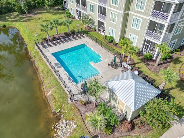 view of swimming pool with a yard, a patio, and a water view