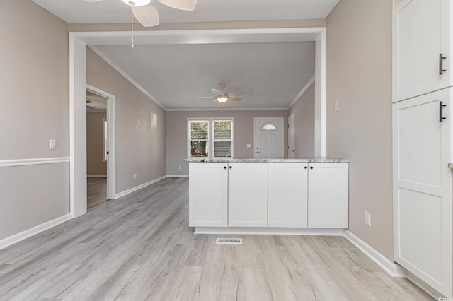 kitchen with white cabinetry, crown molding, light hardwood / wood-style flooring, and ceiling fan