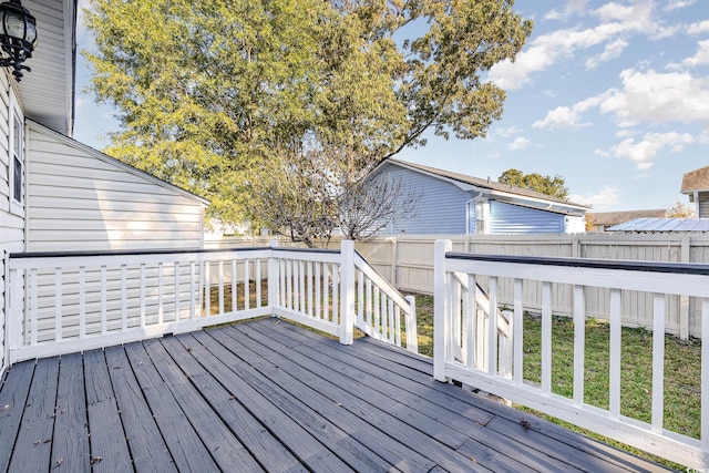 wooden terrace featuring a lawn