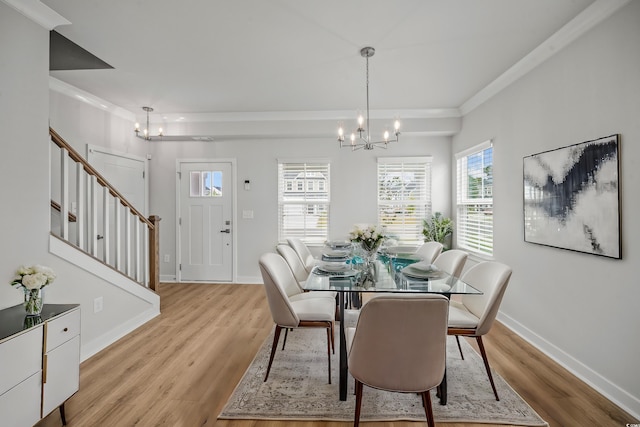 dining room with light hardwood / wood-style flooring, a notable chandelier, and ornamental molding