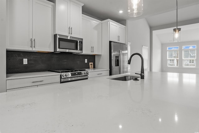 kitchen with white cabinetry, appliances with stainless steel finishes, hanging light fixtures, and sink