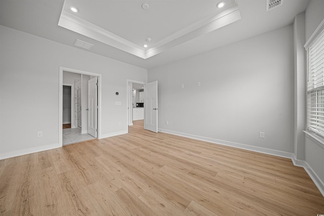 unfurnished room with light hardwood / wood-style floors and a raised ceiling