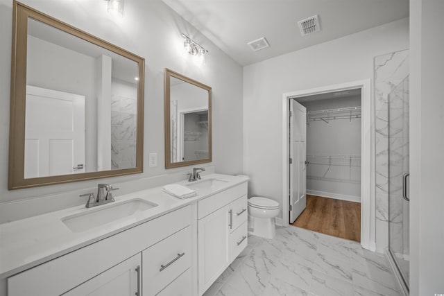 bathroom with walk in shower, vanity, and toilet