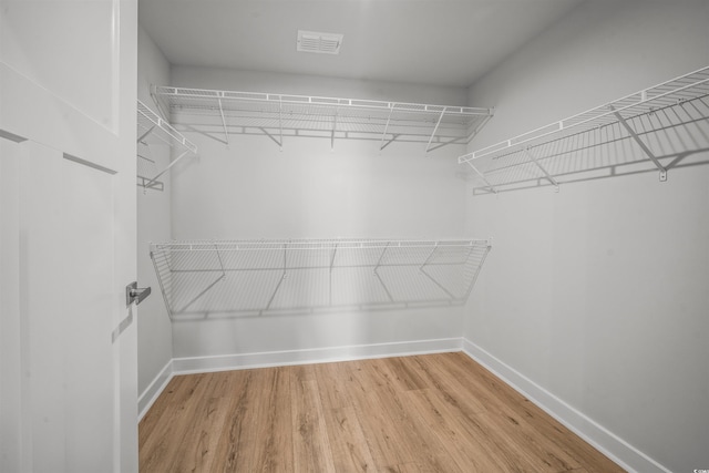 walk in closet with hardwood / wood-style floors