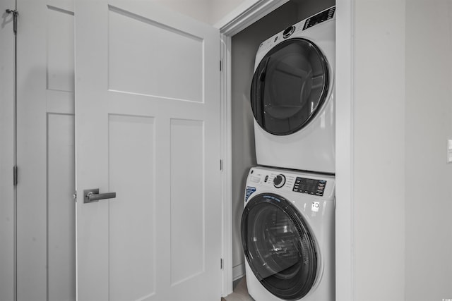 clothes washing area featuring stacked washer / drying machine