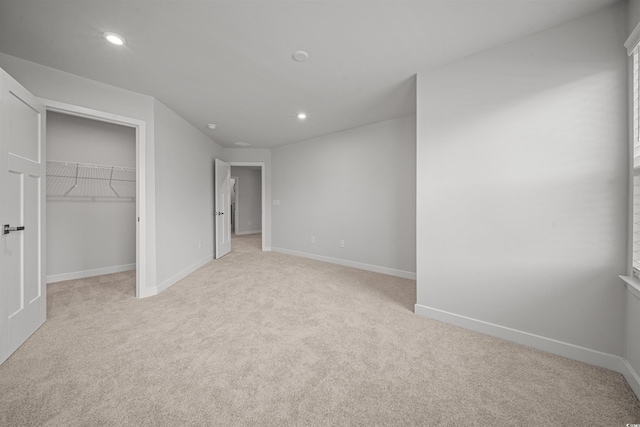 unfurnished bedroom with light carpet and a closet