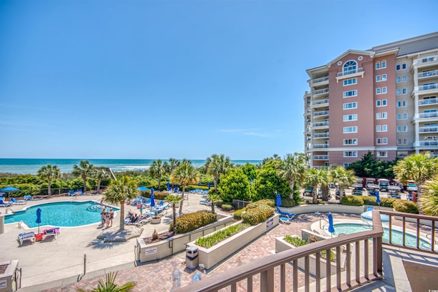 view of swimming pool featuring a water view and a patio area