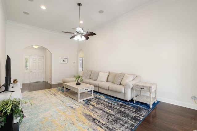 living room featuring dark wood-type flooring, ceiling fan, and ornamental molding