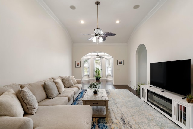 living room featuring hardwood / wood-style flooring, ceiling fan, and ornamental molding