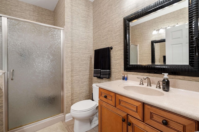 bathroom featuring toilet, a shower with shower door, tile patterned floors, and vanity