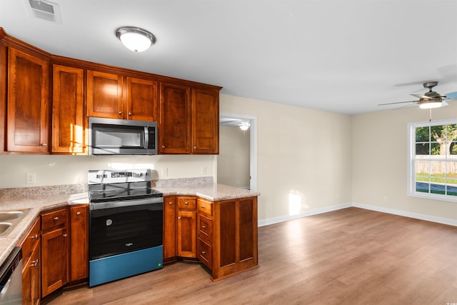 kitchen with ceiling fan, appliances with stainless steel finishes, light hardwood / wood-style flooring, and light stone counters