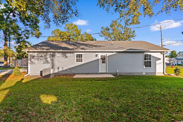 back of property featuring central AC and a lawn