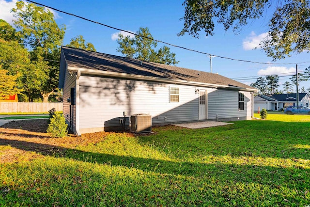 rear view of property with a yard and central air condition unit