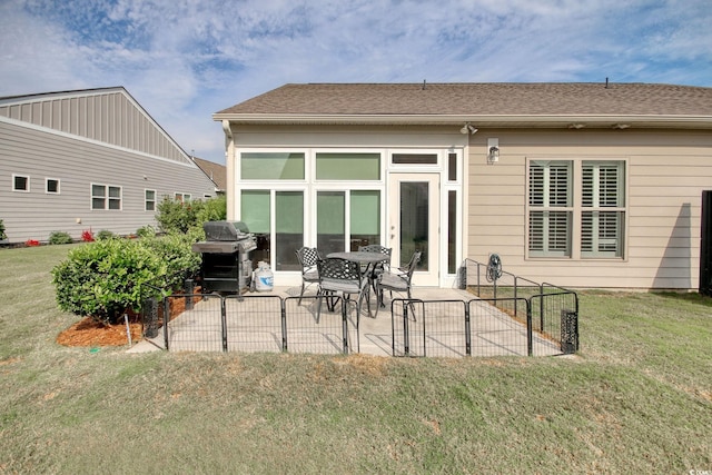 rear view of property featuring a patio and a lawn